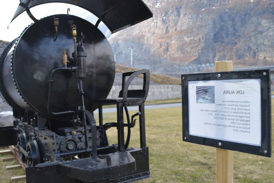 A train engine from the construction period has been restored and placed outside the power plant